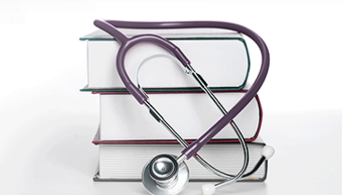 A stethoscope placed on a stack of books